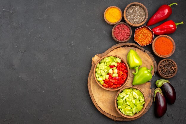 Vista superior de diferentes condimentos con verduras frescas en negro