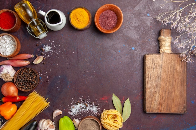 Vista superior de diferentes condimentos con verduras frescas sobre fondo oscuro ensalada de comida picante salud pimienta