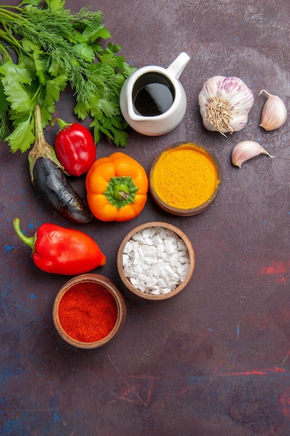 Vista superior de diferentes condimentos con verduras sobre fondo oscuro producto alimenticio de comida de ensalada