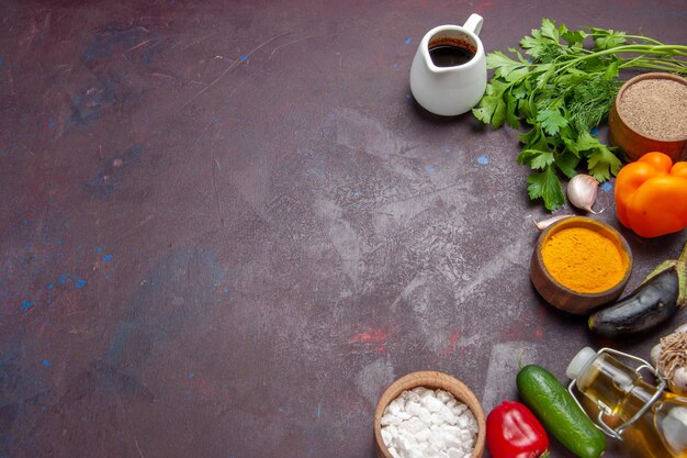 Vista superior de diferentes condimentos con verduras y verduras sobre un fondo oscuro ensalada de alimentos saludables vegetales