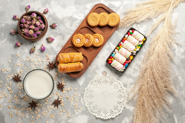 Vista superior de diferentes cosas dulces caramelos y galletas en la superficie blanca galleta de azúcar pastel dulce pastel de galleta
