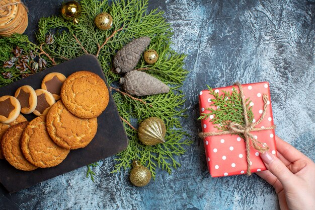 Vista superior diferentes deliciosas galletas con presente en mesa de luz