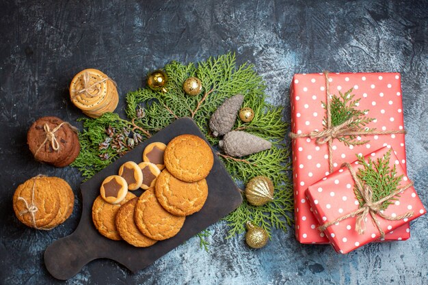 Vista superior diferentes deliciosas galletas con regalos en mesa de luz