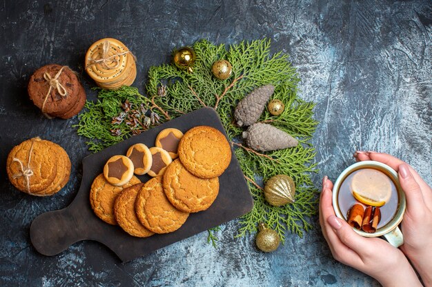 Vista superior diferentes deliciosas galletas con taza de té en la mesa de luz