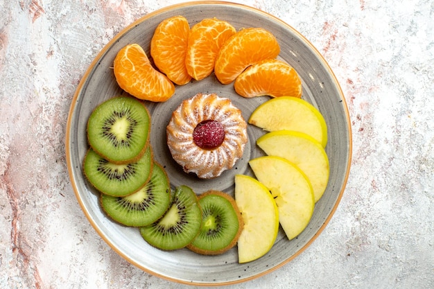 Vista superior de diferentes frutas composición frutas frescas y en rodajas sobre fondo blanco frutas maduras color suave salud