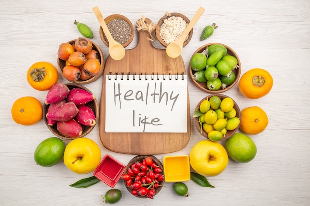 Vista superior de diferentes frutas frescas dentro de placas sobre fondo blanco dieta de color maduro suave vida sana exótica