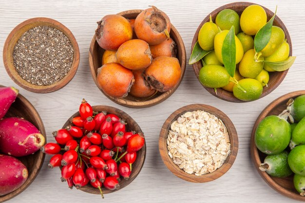 Vista superior de diferentes frutas frescas dentro de placas sobre fondo blanco dieta de color de vida sana exótica madura