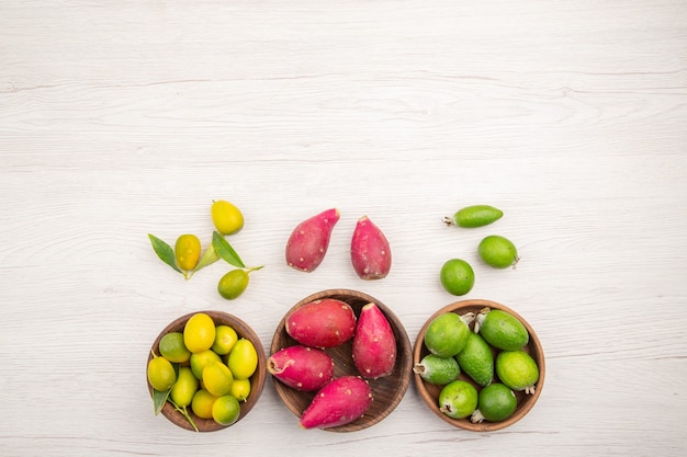 Vista superior de diferentes frutas frescas dentro de placas sobre fondo blanco exótica dieta madura color vida saludable tropical