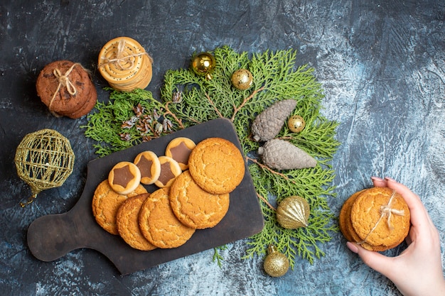 Vista superior de diferentes galletas deliciosas con juguetes y conos en la mesa de luz