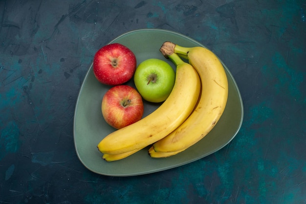 Vista superior de diferentes manzanas y plátanos de composición de frutas en el escritorio azul oscuro