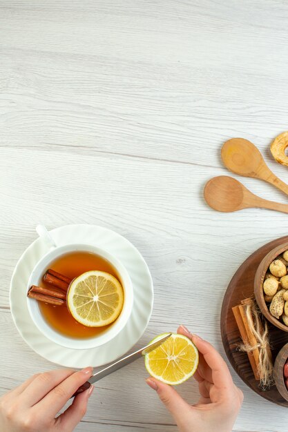 Vista superior diferentes nueces cacahuetes avellanas y nueces con taza de té en mesa blanca