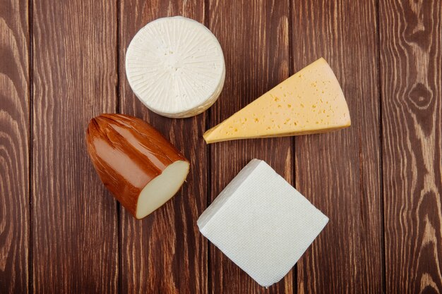 Vista superior de diferentes tipos de queso en la mesa de madera rústica