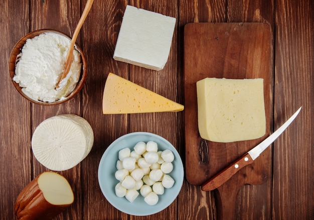 Vista superior de diferentes tipos de queso en la mesa de madera rústica