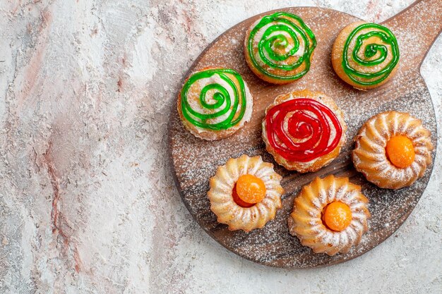 Vista superior de diferentes tortas dulces pequeños sobre fondo blanco galleta galleta azúcar té dulce pastel