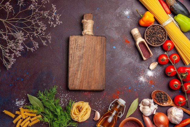 Vista superior de diferentes verduras con diferentes condimentos en el color del producto de ensalada de salud de fondo oscuro