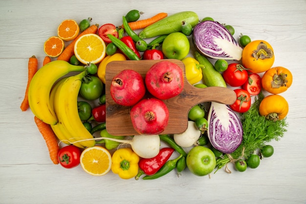 Vista superior de diferentes verduras con frutas sobre fondo blanco, dieta, alimentos, salud, ensalada de color maduro