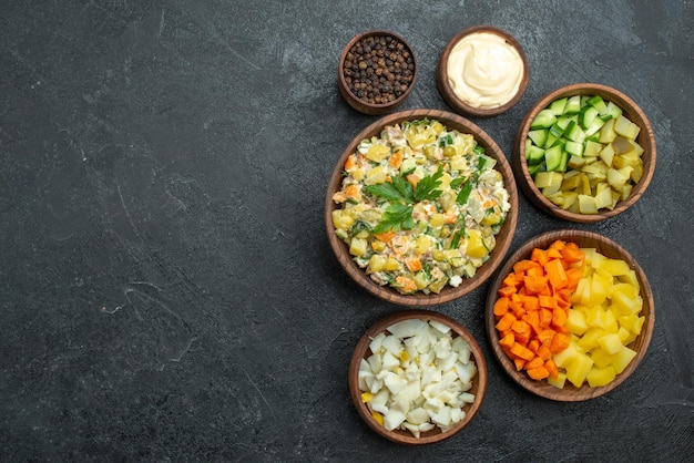 Vista superior de diferentes verduras en rodajas en la superficie oscura comida snack ensalada de verduras