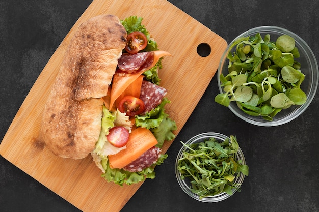 Vista superior disposición de deliciosos sándwiches en tablero de madera