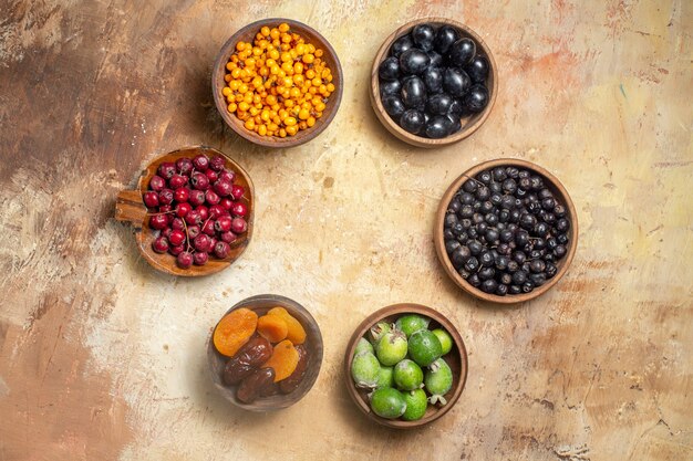 Vista superior de diversas frutas frescas en pequeñas macetas marrones