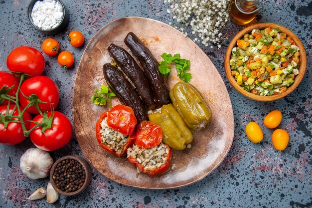 Vista superior dolma de berenjena con tomates cocidos y pimientos rellenos de carne molida dentro de la placa, plato cena comida color