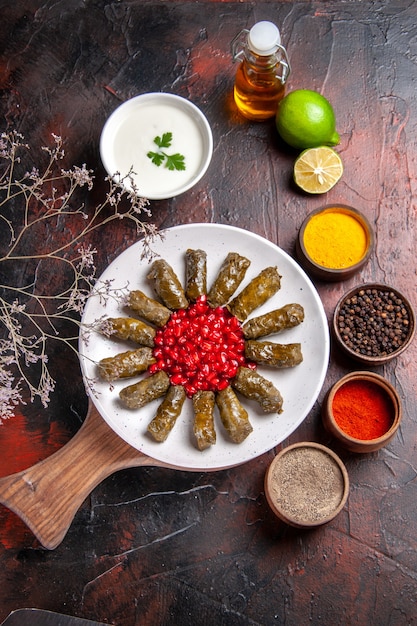 Vista superior de la dolma de hoja verde con condimentos en la superficie oscura