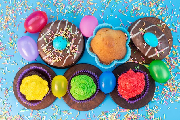 Una vista superior de donas y brownies deliciosos y basados en chocolate junto con caramelos en azul, color de galleta de pastel de caramelo