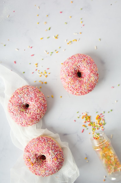 Foto gratuita vista superior de donas glaseadas y una botella de chispas