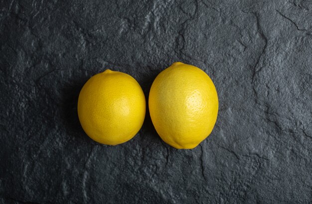 Vista superior de dos limón maduro fresco sobre fondo negro