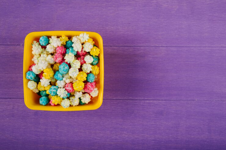 Foto gratuito vista superior de dulces coloridos dulces de azúcar en un tazón sobre fondo de madera púrpura con espacio de copia