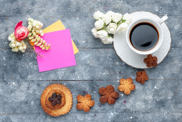 Vista superior dulces deliciosas galletas con taza de café el fondo gris galleta galleta dulce