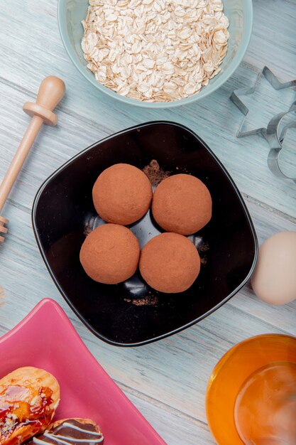 Vista superior de dulces en un tazón con copos de avena mantequilla huevo sobre mesa de madera