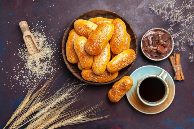 Vista superior empanadas dulces con taza de té y chocolate en el fondo oscuro comida pastelería masa té comida empanada