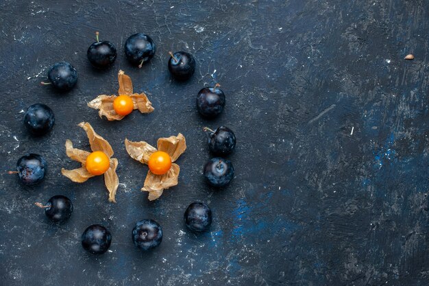 Vista superior de endrinos frescos forrados en círculo en el escritorio oscuro, vitamina baya de frutas frescas