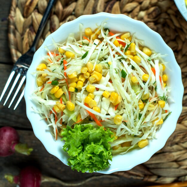 Vista superior ensalada de col ligera con lechuga de maíz y rábano