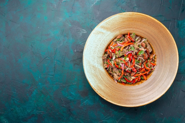 Vista superior de ensalada fresca en rodajas con carne dentro de la placa en azul oscuro, comida de ensalada, almuerzo de carne