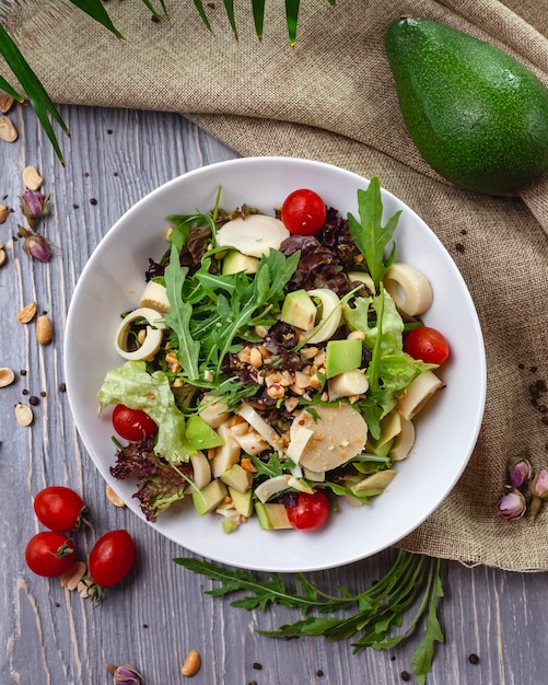 Vista superior ensalada fresca con rúcula aguacate y tomate