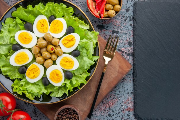 Vista superior de ensalada de huevo ensalada verde y aceitunas sobre fondo claro