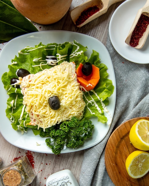 Vista superior ensalada de mimosa en hoja de lechuga con aceitunas