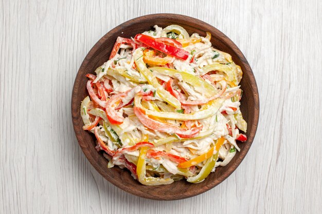 Vista superior de ensalada de pollo con mayyonaise y verduras en rodajas dentro de la placa en el escritorio blanco, ensalada fresca, carne, merienda.