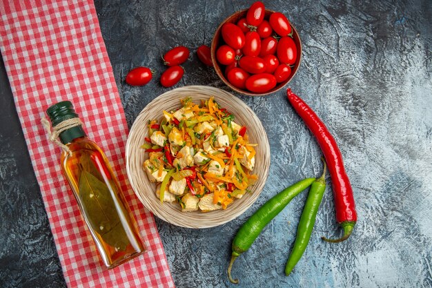 Vista superior de ensalada de pollo con tomates rojos en superficie clara