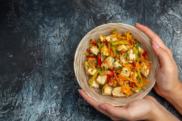 Vista superior de ensalada de pollo con verduras en rodajas sobre superficie clara