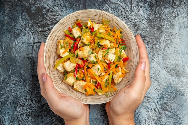 Vista superior de ensalada de pollo con verduras en rodajas sobre superficie clara