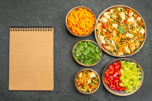 Vista superior de ensalada de pollo con verduras y verduras en la mesa oscura dieta ensalada salud