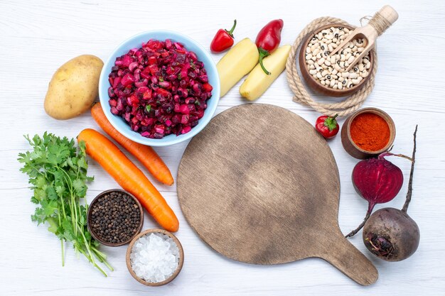 Vista superior de la ensalada de remolacha fresca con verduras en rodajas junto con frijoles crudos zanahorias patatas en blanco, comida comida ensalada fresca de verduras