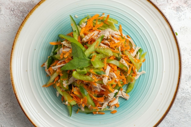 Foto gratuita vista superior de ensalada en rodajas con pollo dentro de la placa sobre fondo blanco.