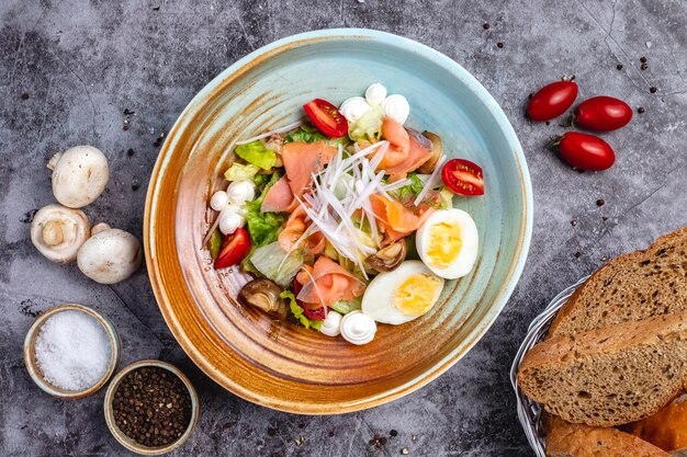 Vista superior de ensalada de salmón ahumado con huevo cocido lechuga tomate tomate cebolla