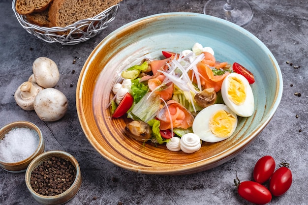 Vista superior de ensalada de salmón ahumado con huevo cocido lechuga tomate tomate cebolla