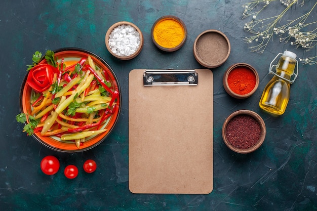 Foto gratuita vista superior ensalada saludable de pimientos en rodajas con diferentes condimentos sobre fondo azul oscuro