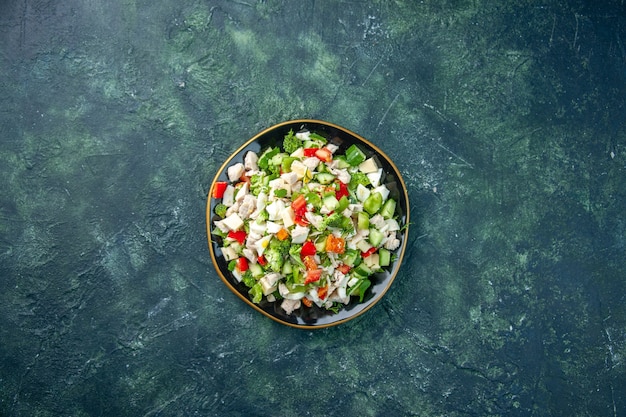 Vista superior ensalada de verduras consiste en queso, pepinos y tomates sobre fondo azul oscuro, color, almuerzo saludable, comida fresca, comida