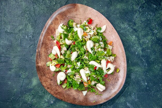 Vista superior ensalada de verduras dentro de la placa elegante en el color de fondo azul oscuro dieta comida cocina restaurante comida saludable almuerzo
